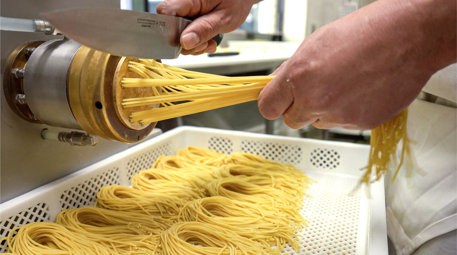 Fresh spaghetti extruded from a brass die and cut by hand into a drying tray